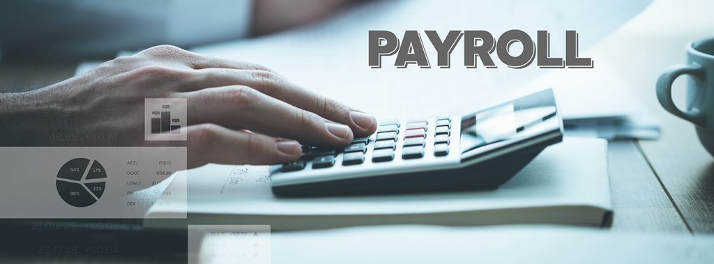 Hand on calculator to determine payroll