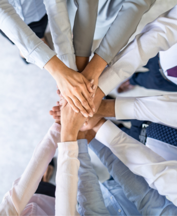 Image of hands stacked upon each other after a business meeting.